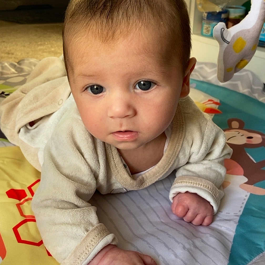 Thélio a rejoint le concours — aidez-le/la à gagner de superbes lots ! baby, blanket, child, clothing, colorful, curious, cute, expression, face, floor, hands, home, indoors, infant, light, play_mat, playtime, portrait, soft_toys, young