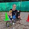 woman, person, dog, german_shepherd, pet, animal, outdoor, sports, competition, trophy, championship, dog_training, training_cone, dog_food, fence, gravel, garden, portrait, sitting, award