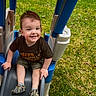 toddler, child, smiling, slide, playground, outdoor, grass, greenery, shorts, tshirt, shoes, plastic, fun, happy, summer, play, recreation, young_child, person, park