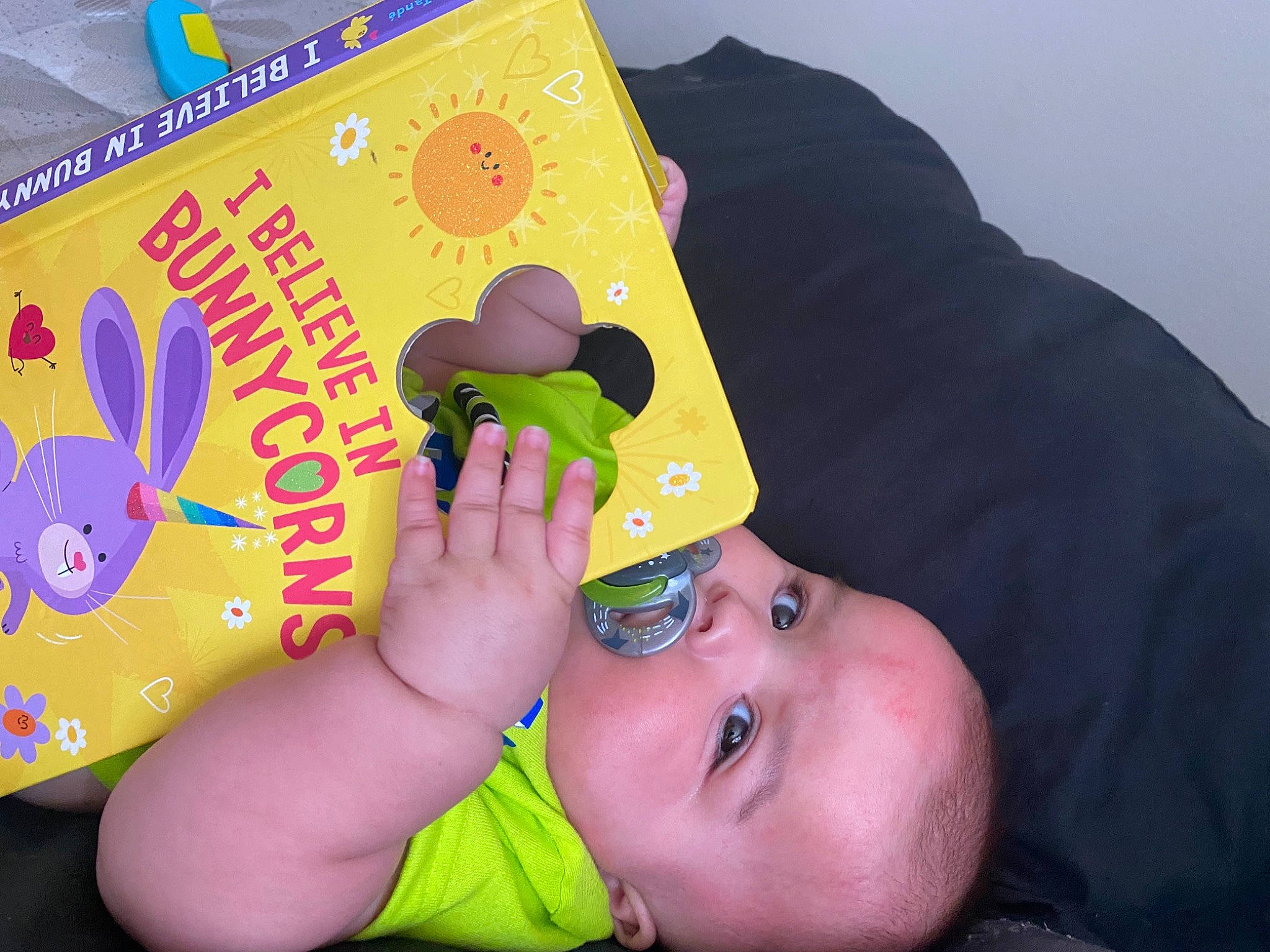 Izaiah is registered to the contest to win money with this photo: animation, baby, baby_playing_with_toys, baby_products, baby_toddler_clothing, child, eyelash, finger, font, fun, hand, happy, leisure, nail, person, play, reading, recreation, thumb, toddler