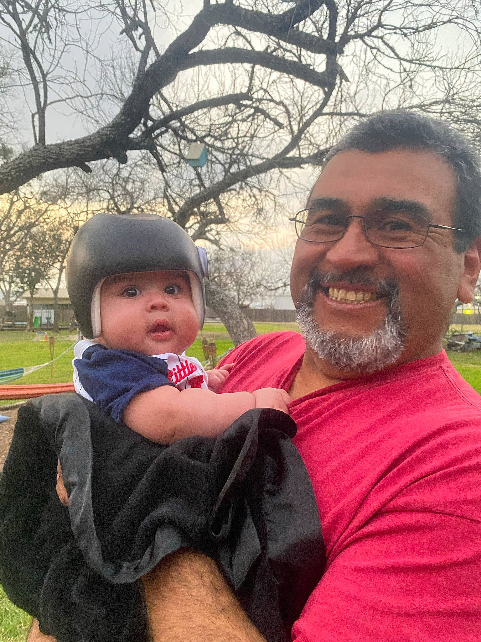 Izaiah is registered to the contest to win money with this photo: baby, beard, event, fun, gesture, grass, happy, headwear, interaction, joy, lap, leaf, leisure, moustache, person, pink, plant, recreation, sky, smile