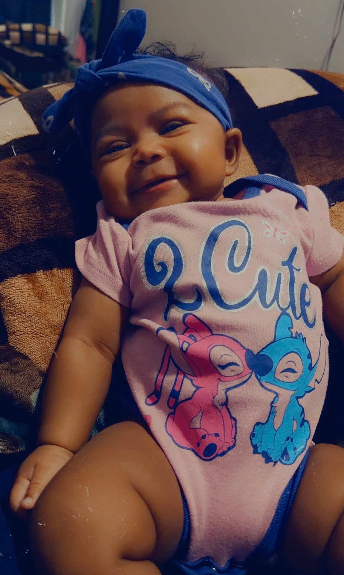 Icelynn Shawnta is registered to the contest to win money with this photo: baby, infant, smiling, headband, onesie, blanket, cute, chubby_cheeks, portrait, indoor, sitting, fabric, pattern, cartoon_print, legs, arm, hand, face, eyes, lips