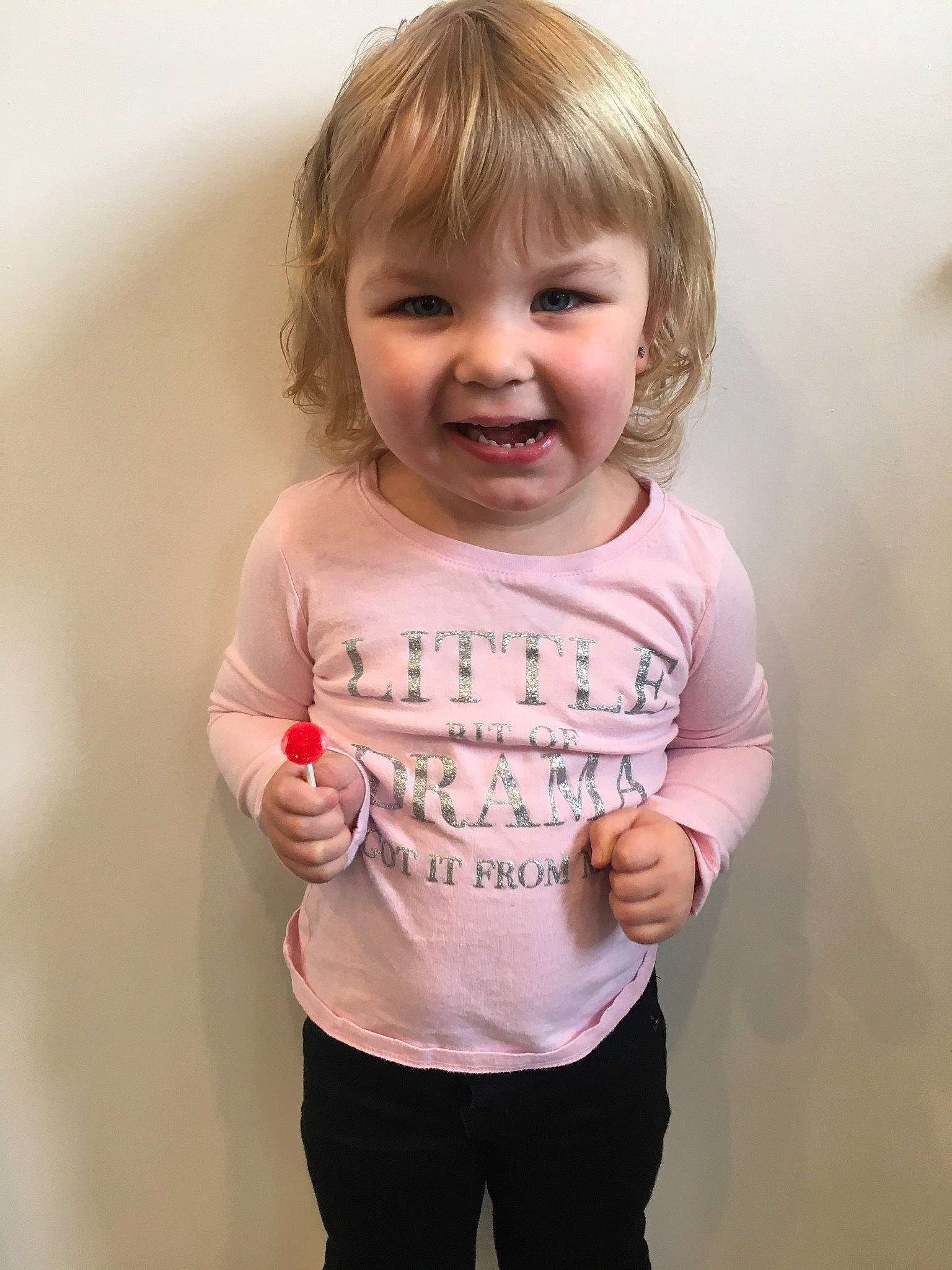 Rori is registered to the contest to win money with this photo: arm, baby, blond, cheek, child, face, facial_expression, head, joint, joy, nose, organ, person, pink, product, shoulder, skin, sleeve, smile, standing