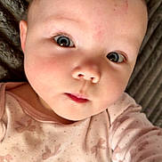 Carmen joined the competition — help win amazing prizes! baby, infant, child, face, blue_eyes, cheeks, onesie, bow_pattern, hand, close_up, portrait, blanket, soft_texture, gaze, skin, forehead, eyelashes, nose, mouth, lying_down