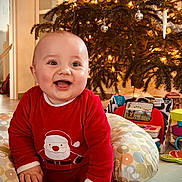 Léandre a rejoint le concours — aidez-le/la à gagner de superbes lots ! baby, child, smiling, christmas_tree, holiday, festive, indoors, red_clothing, toy, cushion, floor, decorations, lights, happy, sitting, cute, face, home, seasonal, celebration