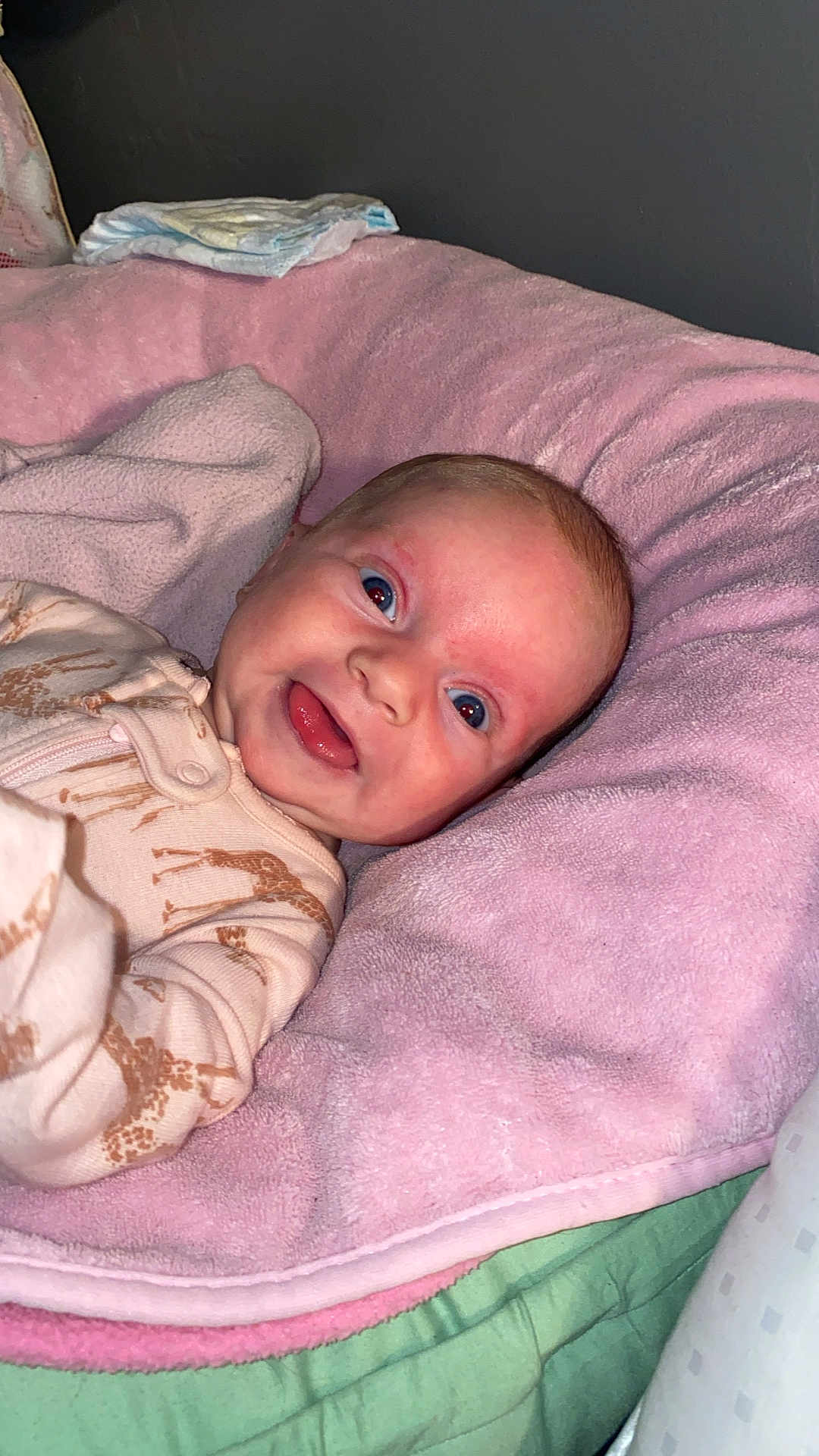 Autumn joined the competition — help win amazing prizes! baby, infant, smiling, face, pink_cushion, onesie, giraffe_pattern, cozy, indoors, child, cute, happy, portrait, newborn, blanket, lying_down, soft_texture, young, person, head