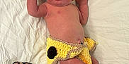 Autumn is registered to the contest to win money with this photo: newborn, baby, infant, crocheted_clothing, giraffe_costume, hat, braided_tail, diaper, hospital_wristband, lying_down, white_sheet, cute, baby_girl, baby_boy, face, skin, hand, foot, expression, portrait