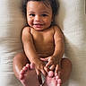 baby, child, smile, curly_hair, bare_skin, feet, hands, cushion, white_background, infant, happy, portrait, cute, playful, closeup, lying_down, human, skin, indoors, person