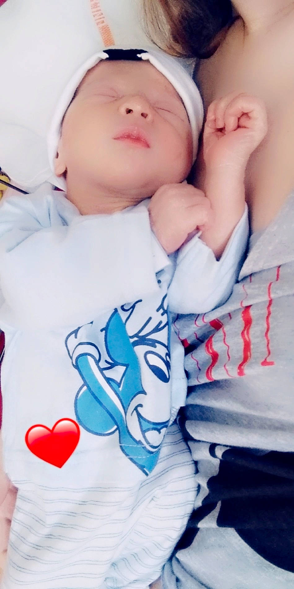 Kévan participe au concours pour gagner de l'argent avec cette photo : baby, baby_sleeping, baby_toddler_clothing, cap, cheek, child, comfort, finger, gesture, happy, lip, mouth, person, pink, red, skin, sleeve, t_shirt, textile, toddler