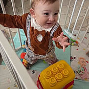 Fiurenzu participe au concours pour gagner de l'argent avec cette photo : toddler, child, baby, playpen, toy, yellow_toy, red_toy, suspenders, bow_tie, plaid_pants, happy, reaching, indoor, floor, playmat, cage, crawling, cute, clothing, person