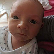 Fiurenzu a rejoint le concours — aidez-le/la à gagner de superbes lots ! baby, infant, face, eyes, close_up, portrait, newborn, clothing, star_pattern, white, skin, head, expression, looking, person, cute, indoors, soft_light, fabric, calm