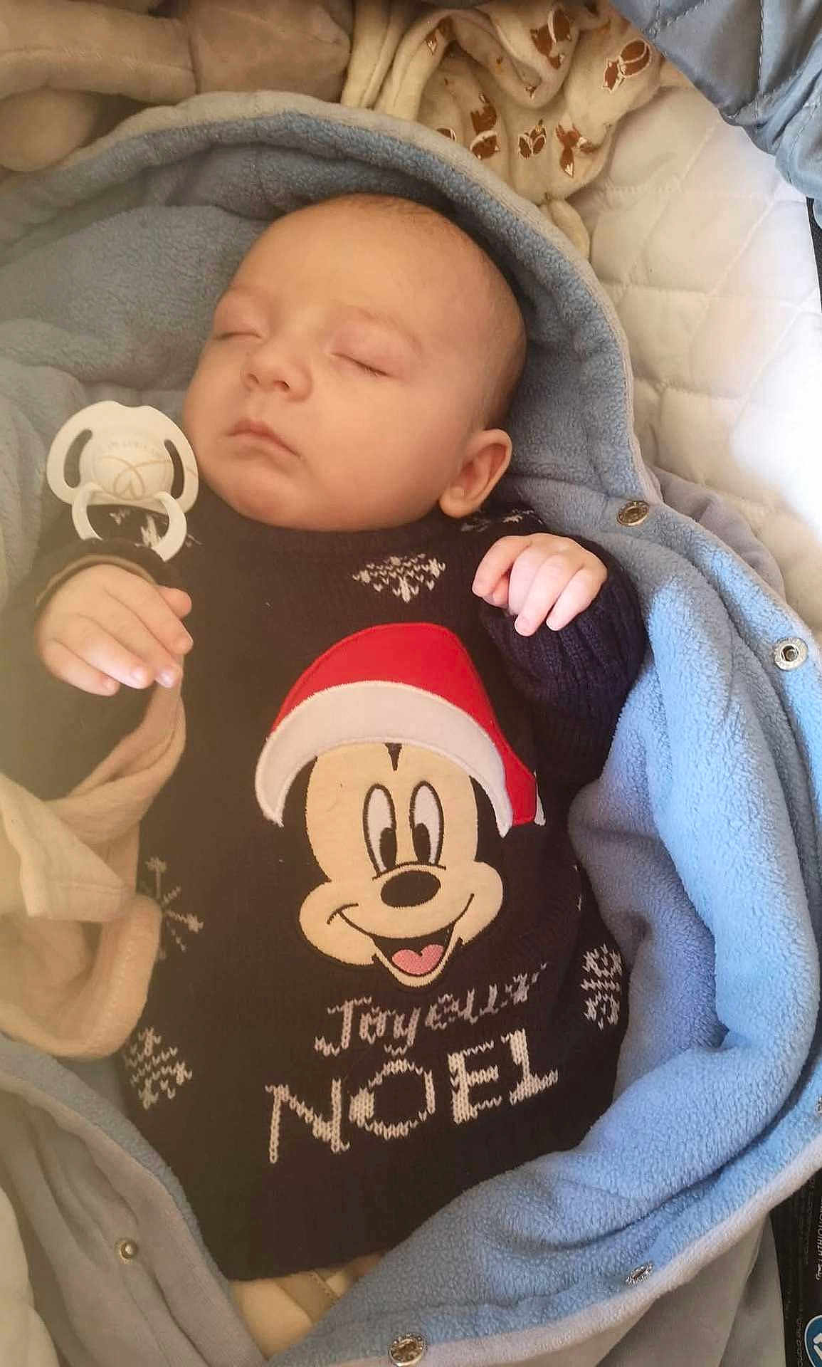 Fiurenzu a rejoint le concours — aidez-le/la à gagner de superbes lots ! baby, sleeping, blanket, pacifier, clothing, mickey_mouse, christmas, holiday, festive, infant, cute, cozy, warm, face, head, hand, soft, child, portrait, resting