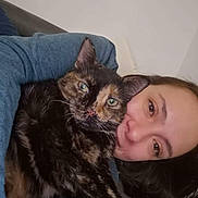 Luna a rejoint le concours — aidez-le/la à gagner de superbes lots ! animal, blue_sweater, cat, closeup, companion, cozy, cuddle, face, feline, fur, home, human, indoor, looking_at_camera, pet, portrait, relaxed, snuggle, tortoiseshell_cat, woman