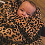 baby, blanket, child, comfort, cozy, cute, face, floor, fur_texture, indoor, infant, leopard_print, pattern, person, portrait, snug, soft, warm, wrapped, young