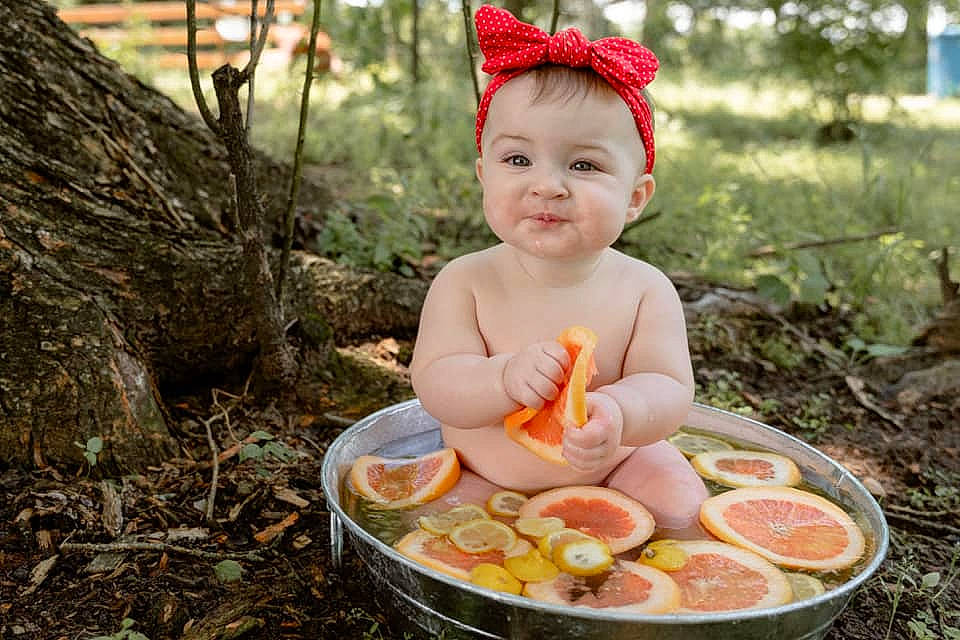 Micha is registered to the contest to win money with this photo: baby, child, comfort_food, cuisine, event, food, fruit, grass, happy, ingredient, leaf, people_in_nature, person, plant, recipe, smile, spring, tableware, toddler, tree