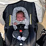 Logan joined the competition — help win amazing prizes! baby, car_seat, infant, sleepy, clothing, socks, straps, floor, legs, shoes, indoors, person, child, sitting, head, face, blanket, comfort, safety, rest