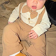 Ayce is registered to the contest to win money with this photo: baby, child, toddler, face, blue_eyes, bow_tie, suspenders, shirt, pants, boots, socks, bed, blanket, indoor, curious, cute, fashion, portrait, person, young