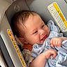 baby, car_seat, blanket, smiling, infant, child, blue_blanket, happy, face, head, clothing, seatbelt, padding, warning_label, person, cute, newborn, indoors, portrait, comfort