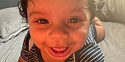 Macai is registered to the contest to win money with this photo: toddler, child, smiling, curly_hair, striped_shirt, indoor, soft_light, close_up, happy, cute, baby, face, portrait, couch, skin, young_child, playful, bright, sunlight, expression
