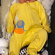 Manuela is registered to the contest to win money with this photo: baby, onesie, yellow_clothing, elephant_design, quilted_blanket, toy, quiet_book, shapes, colors, infant, face, smile, lying_down, cute, indoor, child, soft_toys, cozy, playtime, tactile