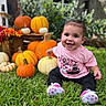 baby, child, smiling, happy, outdoor, pumpkin, pumpkin_patch, autumn, fall, grass, garden, portrait, sitting, pink_shirt, black_pants, sneakers, flowers, gourds, halloween, backyard