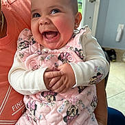 Penelope is registered to the contest to win money with this photo: baby, child, smiling, happy, indoor, person, clothing, pink_outfit, minnie_mouse, long_sleeves, cute, holding, adult, face, cheeks, hands, earrings, door, floor, home