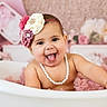 baby, baby_girl, child, cute, decor, floral, flower_headband, happy, head, indoors, infant, pearl_necklace, pink, playful, portrait, sitting, skin, smiling, tongue_out, tub