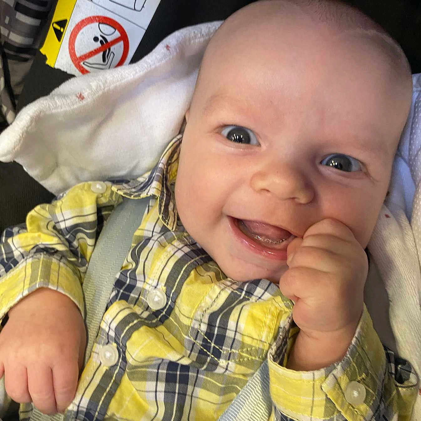 Lyam a rejoint le concours — aidez-le/la à gagner de superbes lots ! baby, buttoned_shirt, car_seat, child, closeup, cute, eyes, face, hand, happy, infant, joyful, mouth, person, plaid_shirt, portrait, seatbelt, smiling, yellow_clothing, young_child