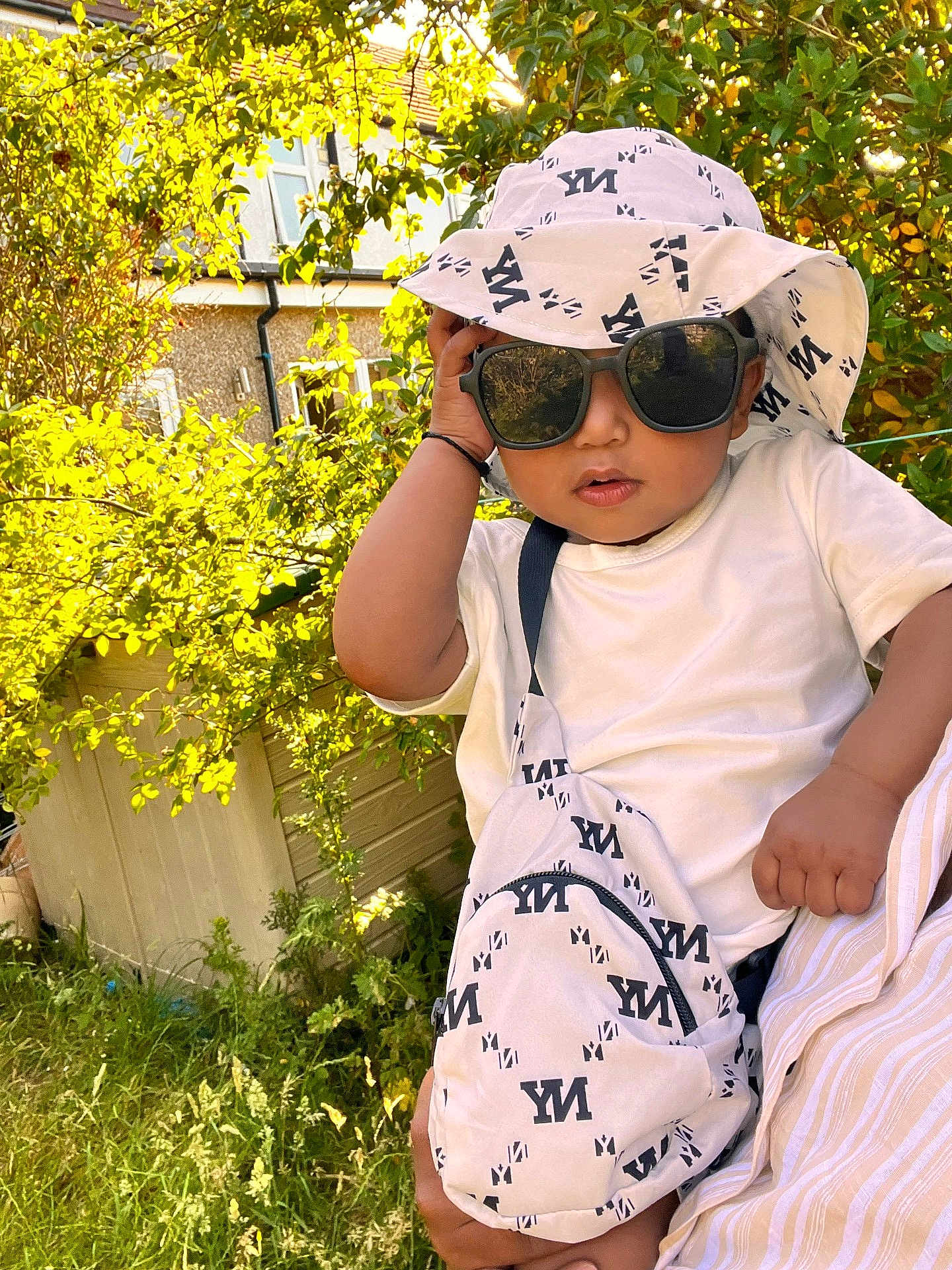 Arsalan joined the competition — help win amazing prizes! baby, bag, child, cute, fashion, garden, grass, greenery, hand, hat, house, ny_print, outdoor, person, portrait, summer, sunglasses, sunlight, toddler, white_clothing