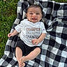 baby, smiling, child, blanket, checkered_pattern, grass, outdoor, shirt, clothing, shorts, happy, face, feet, hand, person, infant, lying_down, nature, casual, daylight