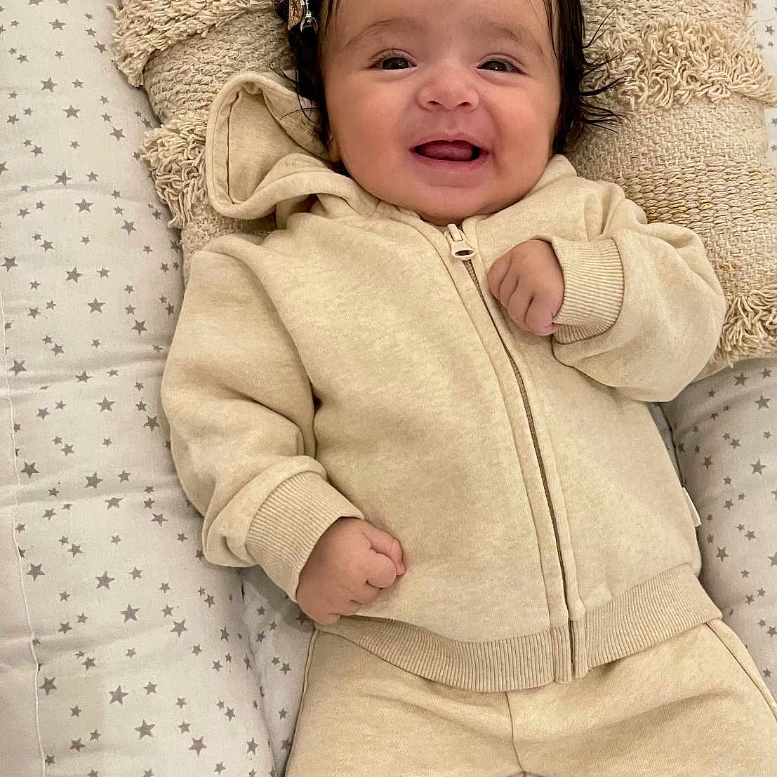 Hidâya a rejoint le concours — aidez-le/la à gagner de superbes lots ! baby, babylaughing, bed, blanket, clothing, coat, cushion, face, furniture, happy, head, homedecor, jacket, knitwear, newborn, pants, person, photography, portrait, smile