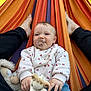Klara a rejoint le concours — aidez-le/la à gagner de superbes lots ! baby, blue_pants, casual, cherry_pattern, child, comfort, feet, giraffe, greenery, hammock, infant, legs, outdoor, pacifier, person, playful, relaxing, smiling, sweater, toy