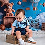 Jayden is registered to the contest to win money with this photo: toddler, child, baby, sitting, blue_shirt, bow_tie, suspenders, wooden_chest, white_sneakers, teddy_bear, hot_air_balloon, stars, clouds, background, floor, cute, indoors, portrait, toy, decor