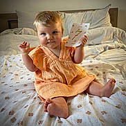 Lou a rejoint le concours — aidez-le/la à gagner de superbes lots ! baby, bed, blanket, card, child, cozy, cute, dress, fabric, face, foot, hair, hand, indoor, infant, pattern, pillow, sitting, smile, soft
