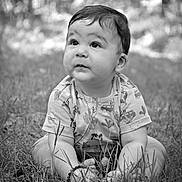 Lyaam participe au concours pour gagner de l'argent avec cette photo : baby, child, grass, outdoor, sitting, black_and_white, portrait, cute, nature, necklace, shirt, young, expression, innocent, curious, person, face, head, hands, feet