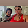 Amir joined the competition — help win amazing prizes! toddler, woman, child, smile, pout, red_tank_top, tattoo, indoor, window, natural_light, curly_hair, casual_clothing, portrait, person, happy, family, home, cute, face, skin