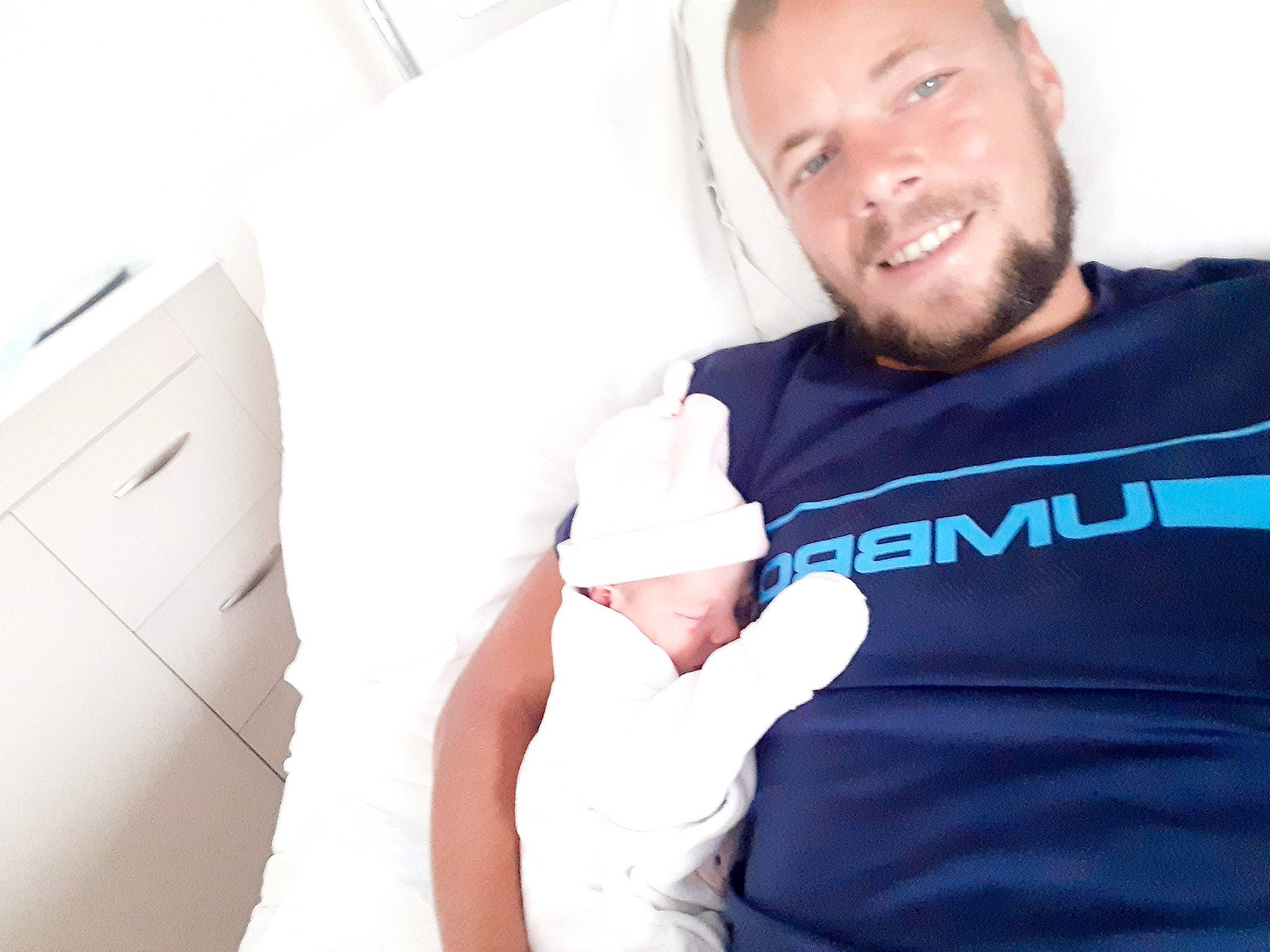 Emy a rejoint le concours — aidez-le/la à gagner de superbes lots ! baby, baby_sleeping, baby_toddler_clothing, beard, cabinetry, chest_of_drawers, child, comfort, facial_hair, finger, gesture, happy, joy, linens, person, shoulder, sitting, sleeve, smile, t_shirt