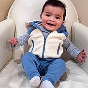 Ansh Dharampuriya joined the competition — help win amazing prizes! baby, child, smiling, fleece_vest, blue_pants, socks, armchair, indoor, happy, cute, portrait, person, seated, furniture, cozy, infant, clothing, comfortable, skin, face