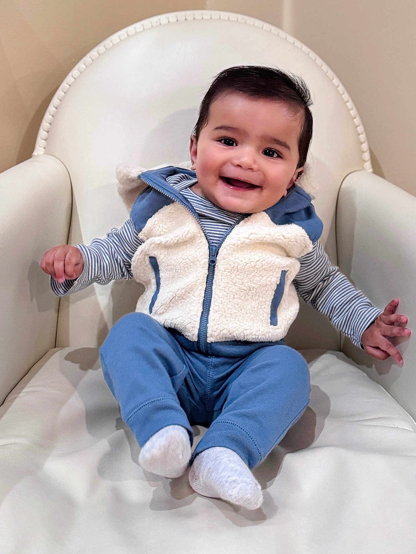 Ansh Dharampuriya joined the competition — help win amazing prizes! baby, child, smiling, fleece_vest, blue_pants, socks, armchair, indoor, happy, cute, portrait, person, seated, furniture, cozy, infant, clothing, comfortable, skin, face