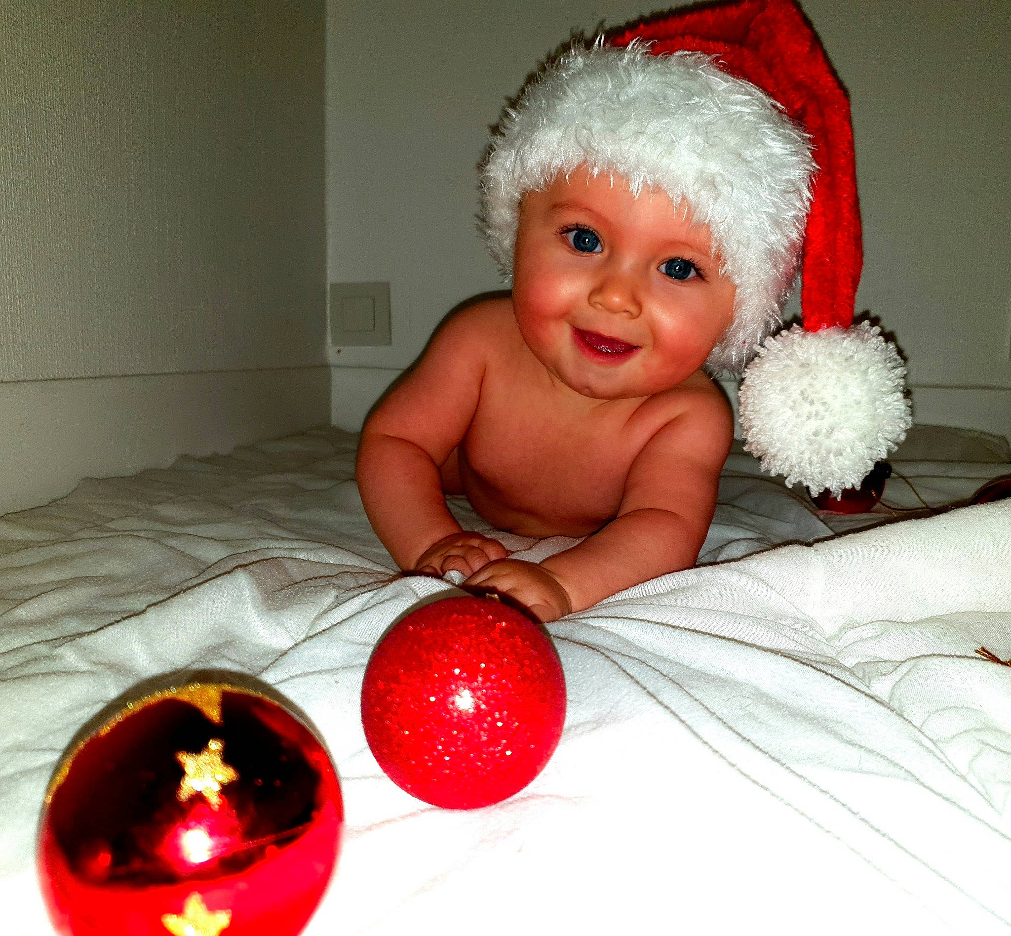 Gabin participe au concours pour gagner de l'argent avec cette photo : baby, child, christmas, christmas_decoration, christmas_eve, christmas_ornament, event, fictional_character, headwear, holiday, interior_design, joy, person, santa_claus, smile, toddler