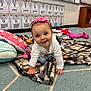 Eliza-Stylez is registered to the contest to win money with this photo: baby, child, crawling, pink_bow, blanket, pillow, toy, classroom, carpet, education, number_chart, floor, headband, smile, happy, indoor, person, furniture, shelf, shoes