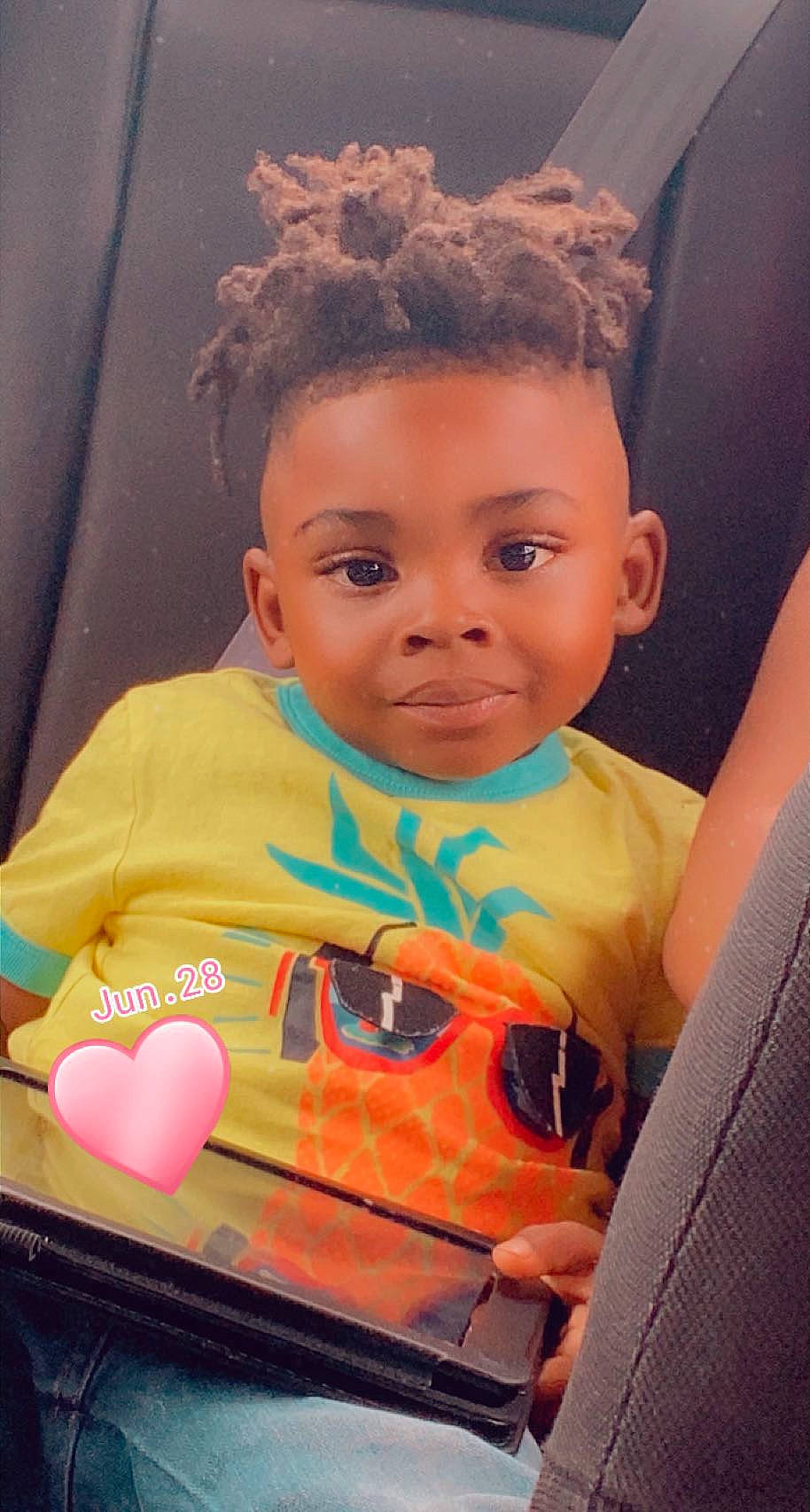 Jamari is registered to the contest to win money with this photo: baby, child, cool, eyebrow, eyewear, fun, hairstyle, happy, iris, leisure, lip, motor_vehicle, mouth, orange, organ, person, skin, standing, t_shirt, toddler