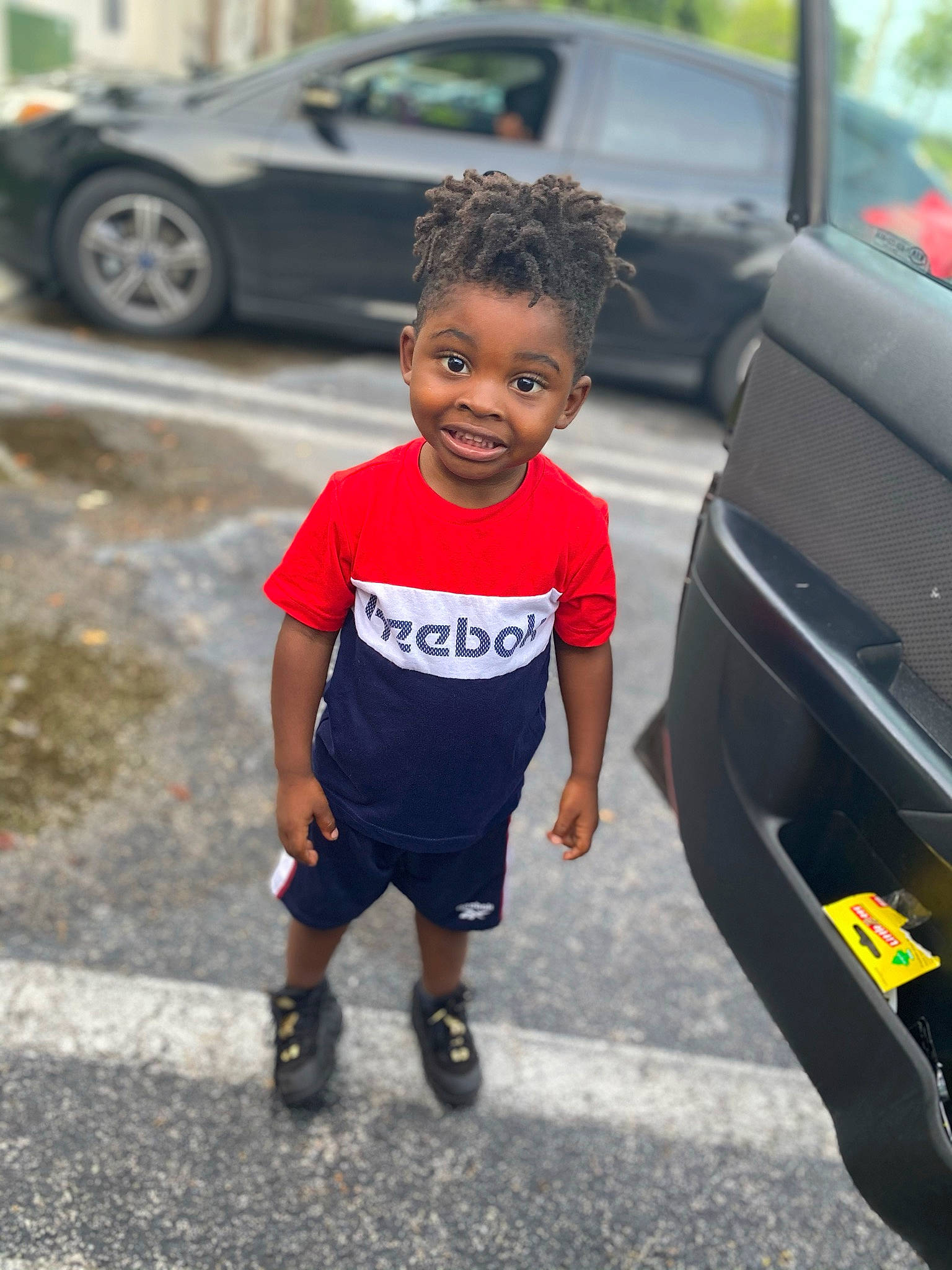 Jamari is registered to the contest to win money with this photo: asphalt, automotive_design, automotive_exterior, automotive_lighting, automotive_tire, car, land_vehicle, motor_vehicle, parking, people, person, personal_luxury_car, public_space, road, sidewalk, street_fashion, tire, toddler, vehicle, vehicle_door