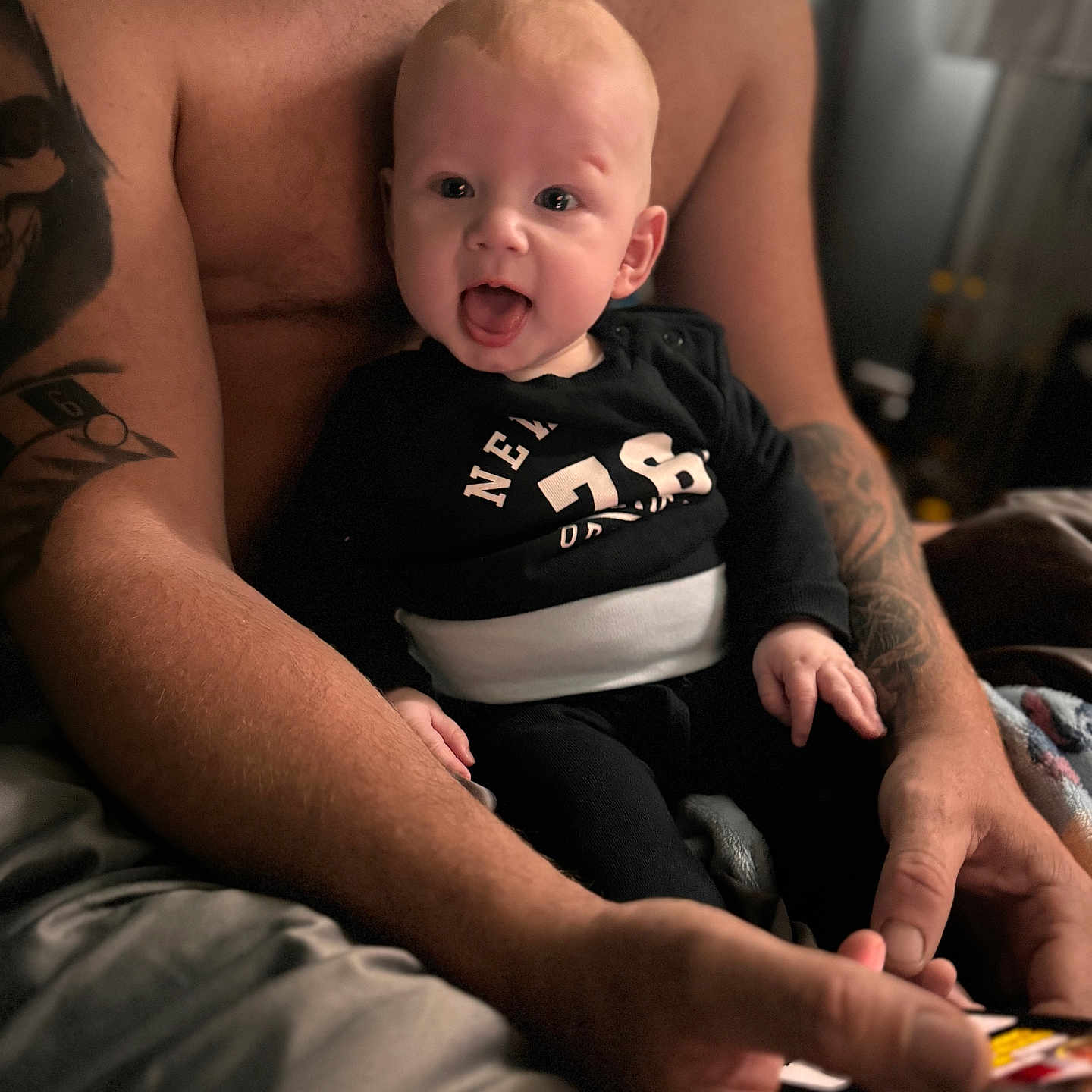 Jacob joined the competition — help win amazing prizes! arm, baby, back, bodypart, clothing, couch, face, finger, furniture, hand, head, newborn, person, photography, portrait, sitting, skin, t_shirt, tattoo, wrist