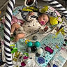 Maëlyne a rejoint le concours — aidez-le/la à gagner de superbes lots ! baby, infant, pacifier, play_mat, toy, mirror, striped_pattern, floor, sock, onesie, child, indoor, flooring, play_gym, colorful, plastic_ball, cushion, hand, head, reflection