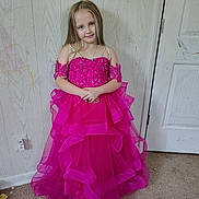 Maycee is registered to the contest to win money with this photo: child, girl, dress, pink_dress, long_hair, standing, carpet, wall, scribbles, door, indoor, smile, portrait, person, floor, home, fabric, clothing, cute, room