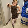 Lainey is registered to the contest to win money with this photo: child, girl, dress, leggings, unicorn, sneakers, shopping_cart, store, floor, mirror, reflection, person, posing, wall, casual, indoor, smile, hair, clothing, aisle