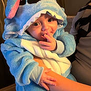 Reign is registered to the contest to win money with this photo: baby, blue, child, clothing, costume, cute, ears, expression, face, hand, holding, hood, indoor, infant, person, plush, portrait, soft, sucking_fingers, warm