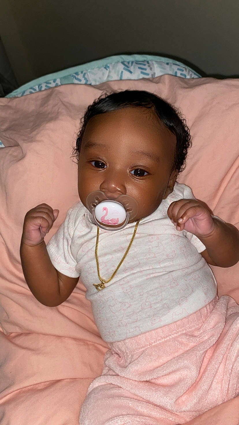 Legacy is registered to the contest to win money with this photo: baby, baby_toddler_clothing, cheek, child, comfort, dress, eye, eyelash, finger, fun, gesture, happy, iris, lip, mouth, nose, person, pink, skin, sleeve