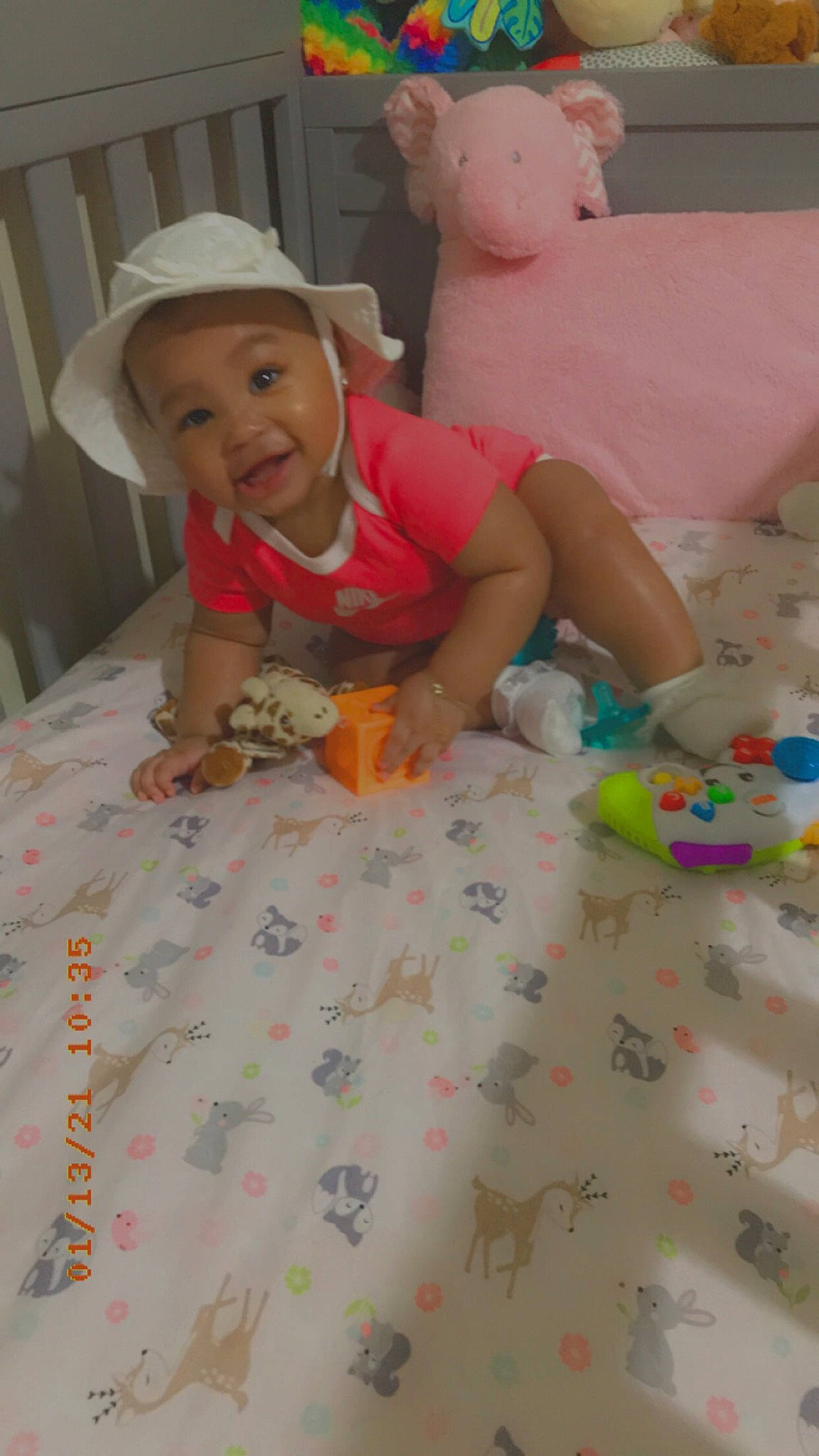 Secret is registered to the contest to win money with this photo: baby, baby_toddler_clothing, baby_toys, bed, bed_sheet, blond, child, costume_accessory, ear, fedora, hat, headwear, human, linens, nose, person, pink, play, skin, sun_hat